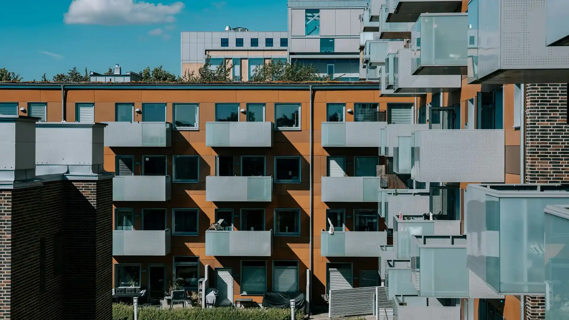 Flerfamiljshus med balkonger i glas.